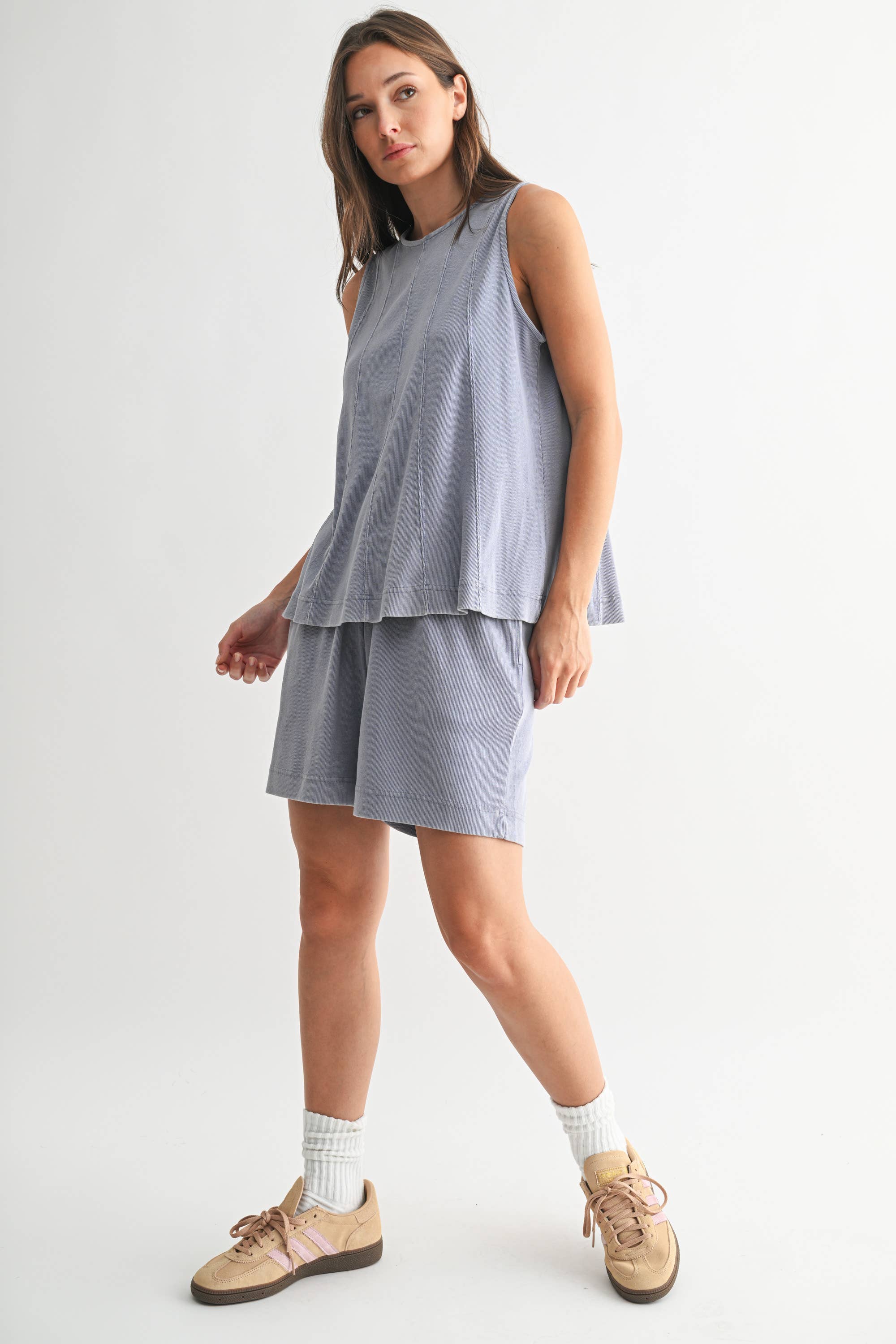 Woman wearing a light blue sleeveless top and skirt set on a white background