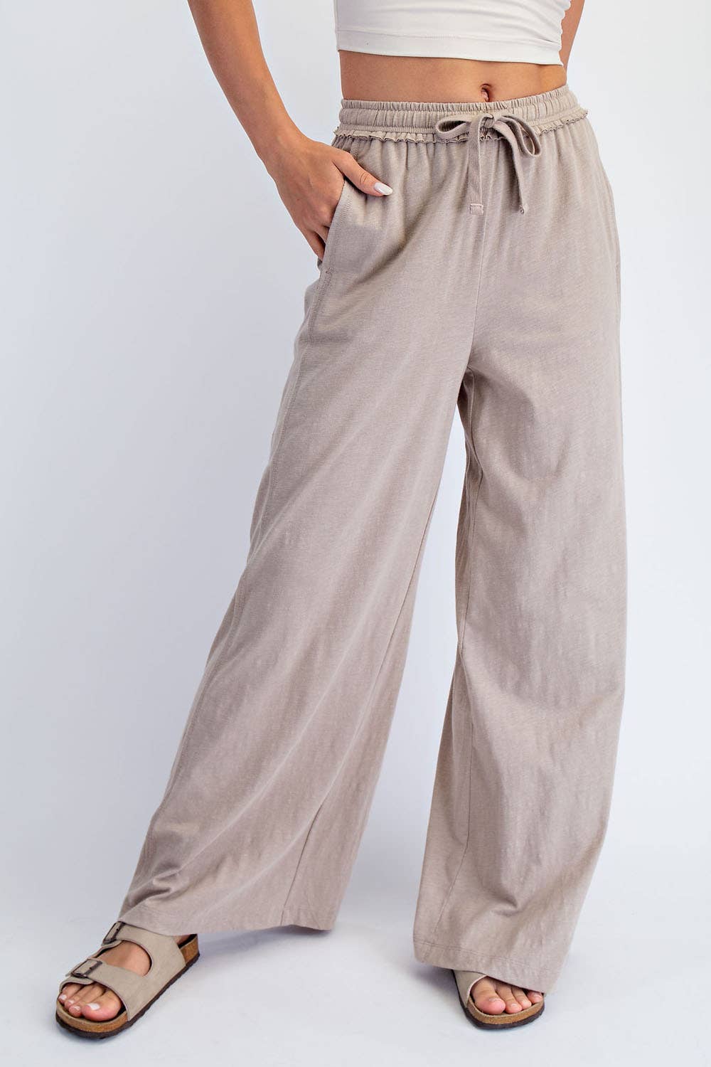 Beige wide-leg pants worn by a person on a white background