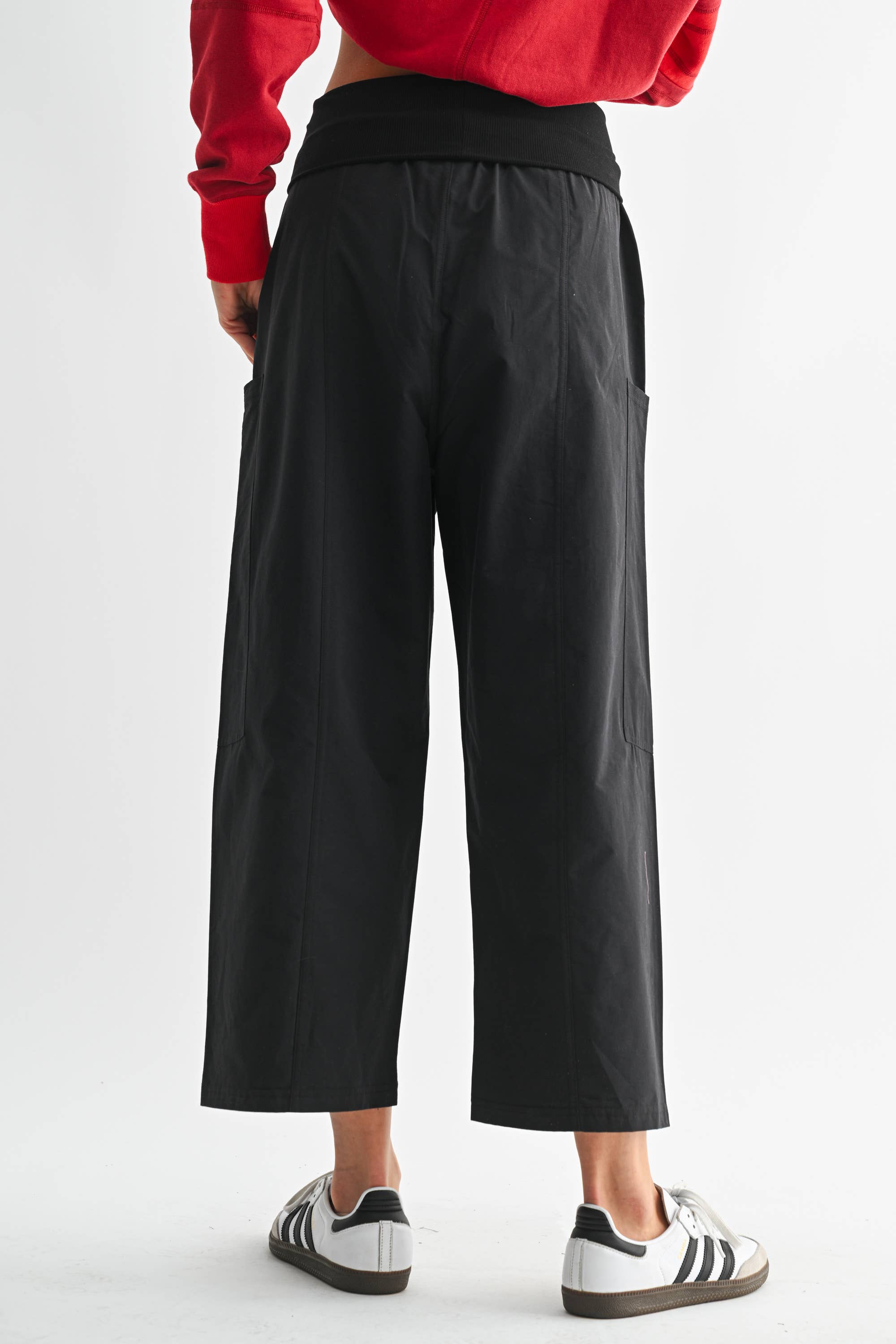 Person wearing black pants and a red top on a white background