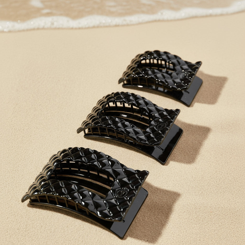 Set of black hair clips on a beige background