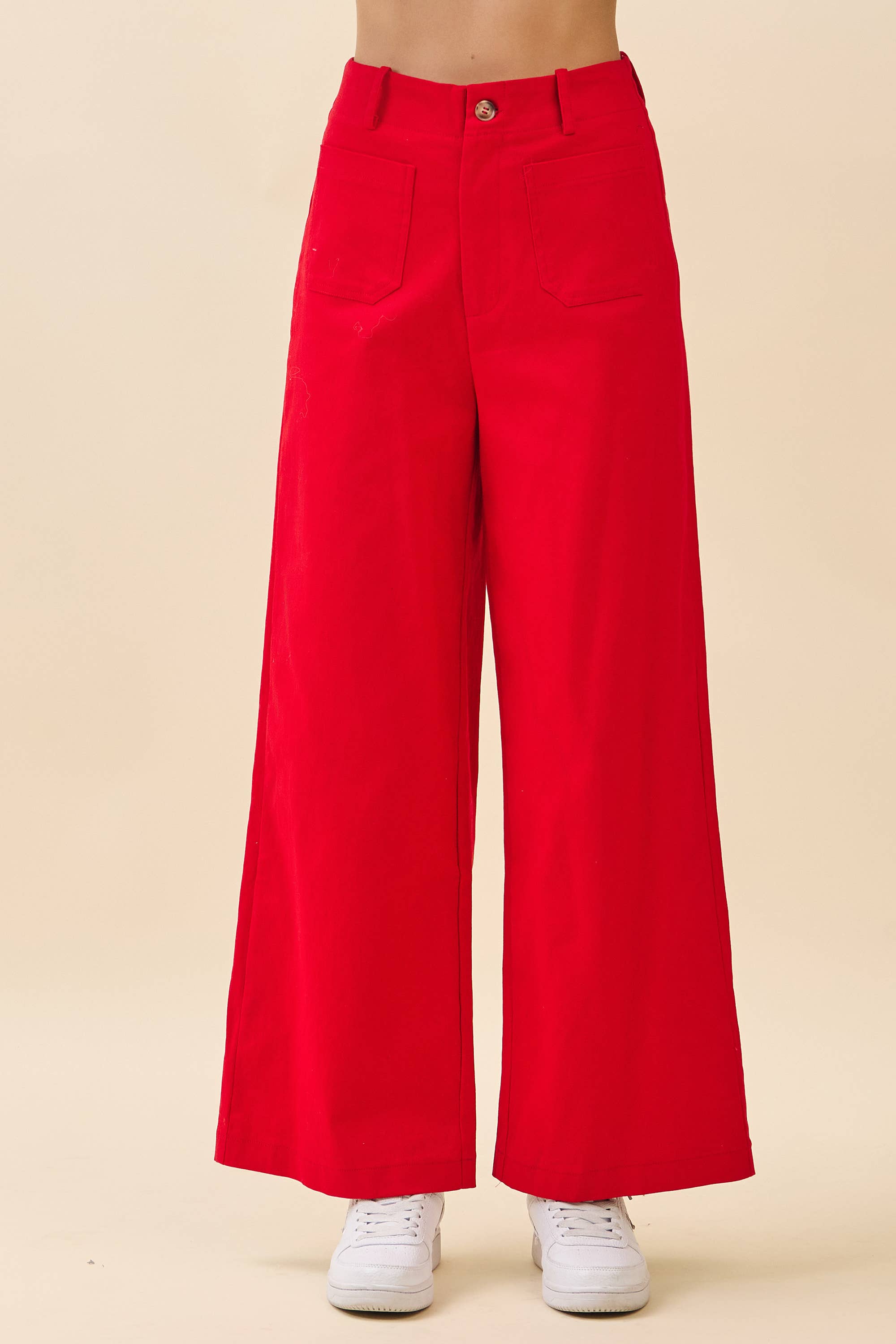Red wide-leg pants worn by a person on a beige background