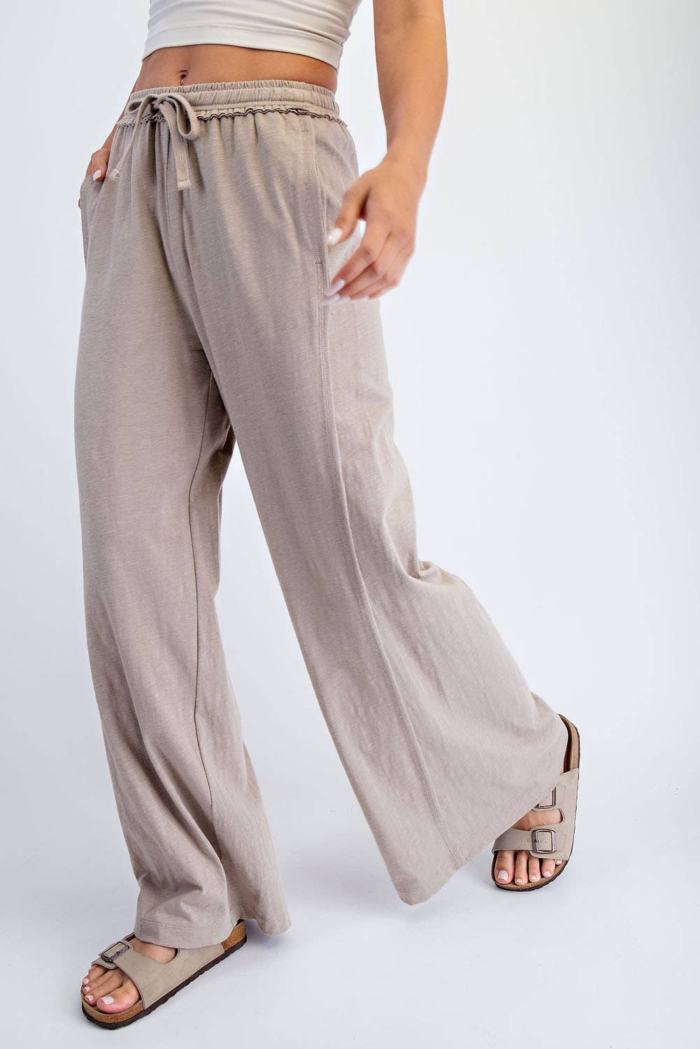 Beige wide-leg pants worn by a person on a white background