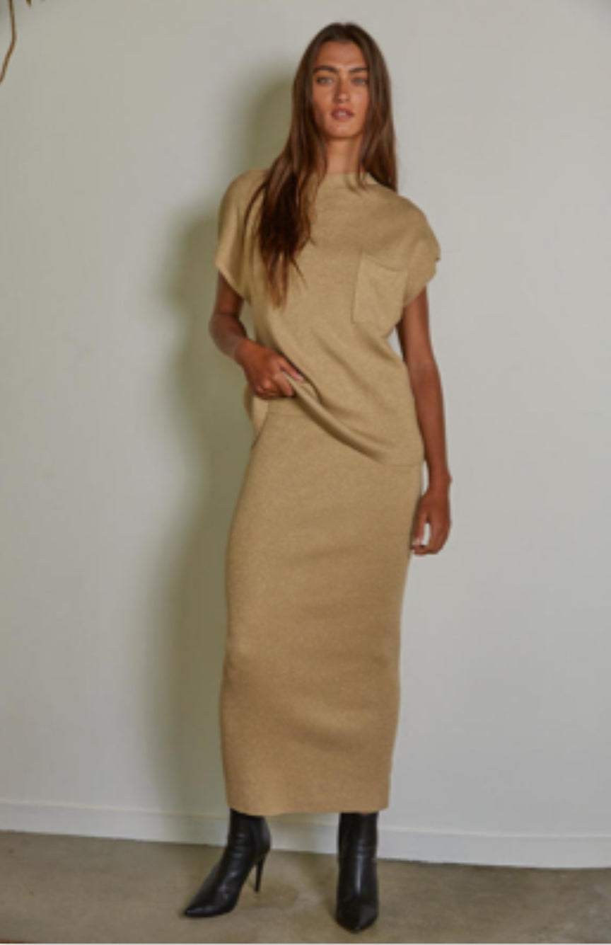 Woman wearing a beige dress against a plain background