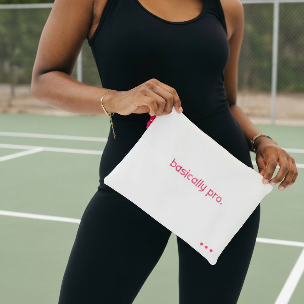 Person holding a white pouch with 'basically pro' text on a plain background