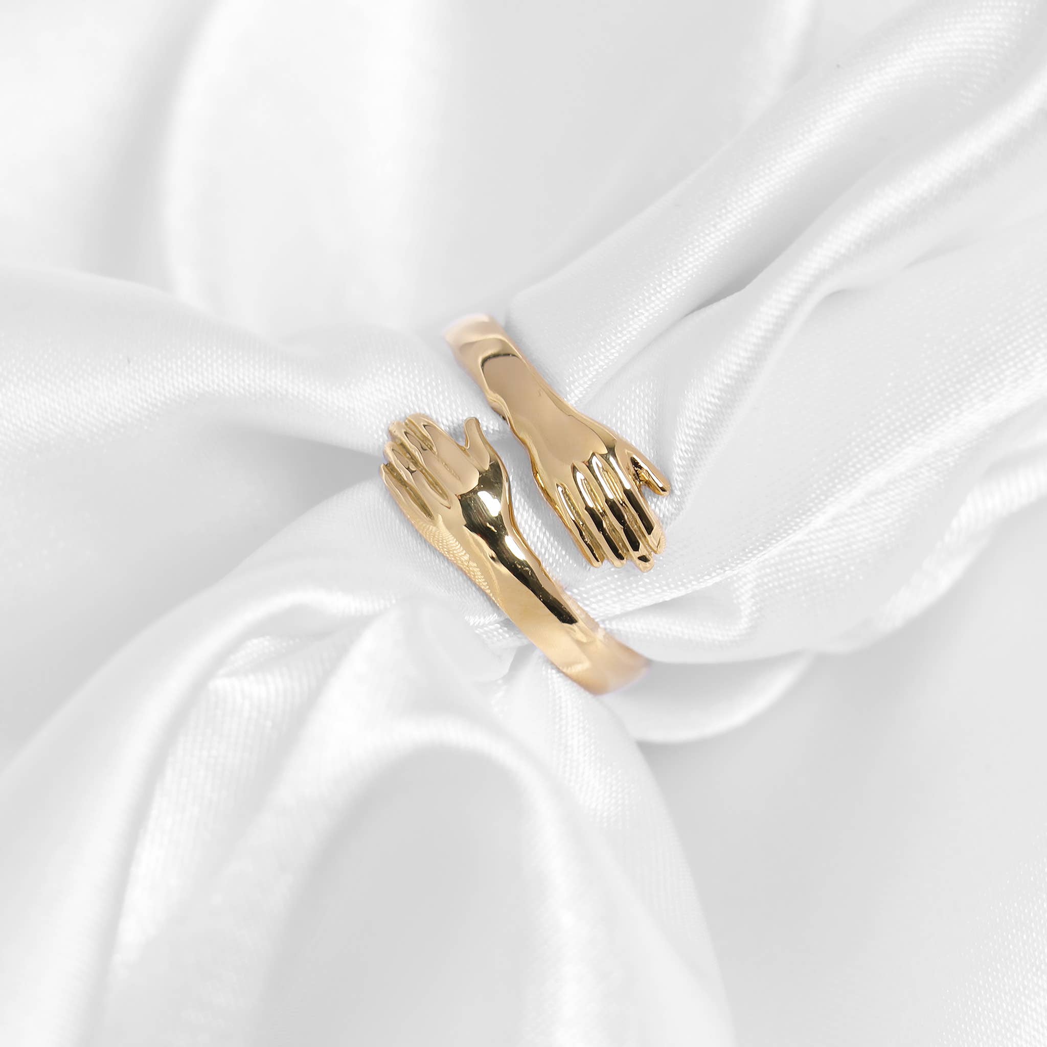 Gold hug ring on a white satin background