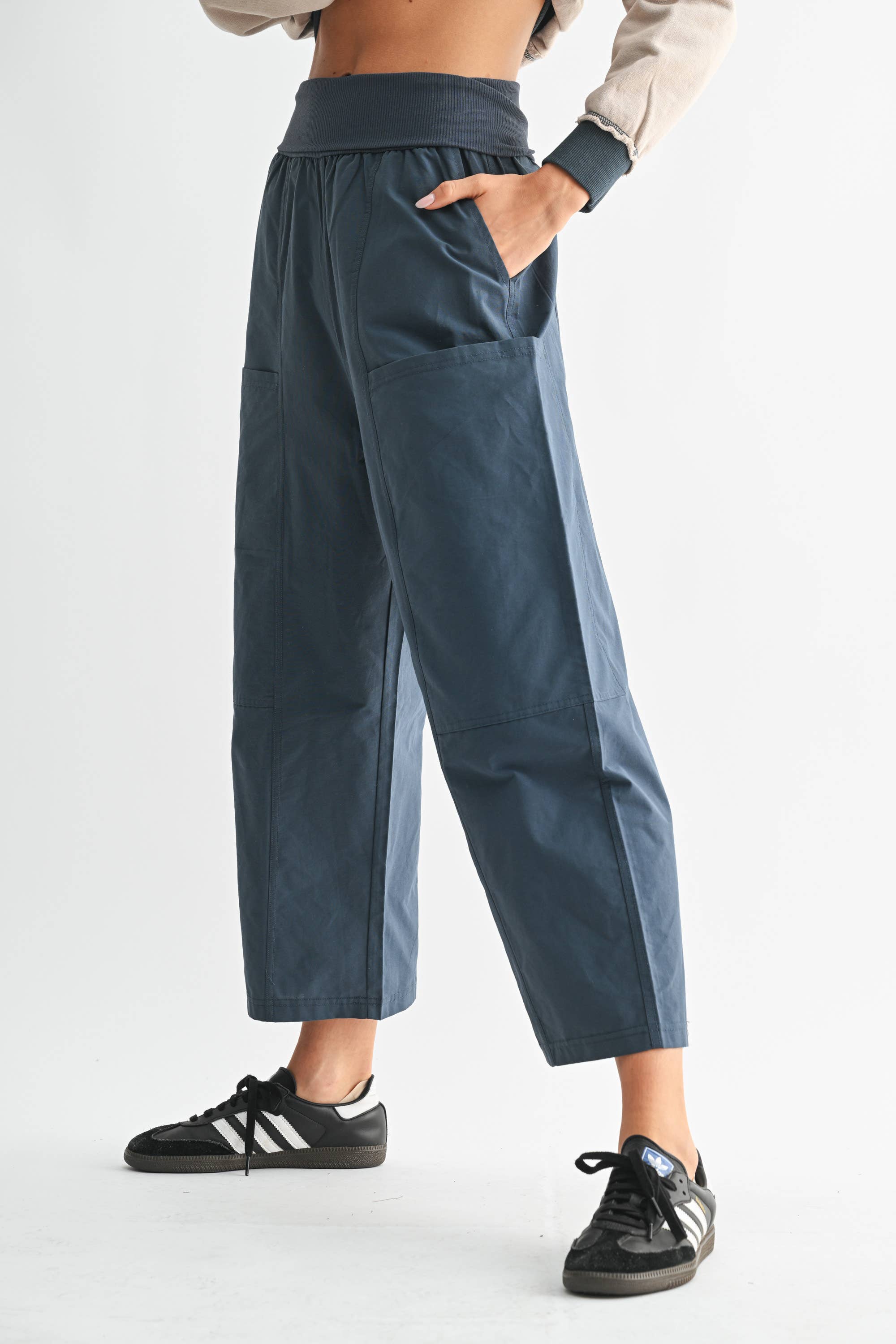Person wearing teal pants with a plain background
