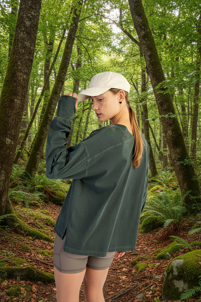 Person wearing a green long-sleeve shirt and beige cap on a white background