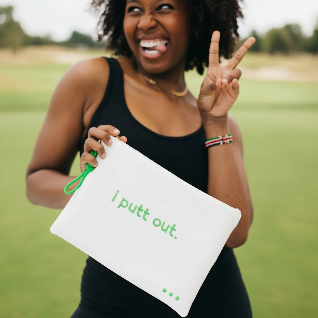Person holding a white pouch with green text, making a peace sign.