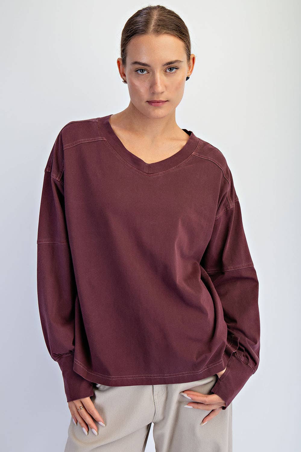 Person wearing a maroon oversized sweatshirt on a white background