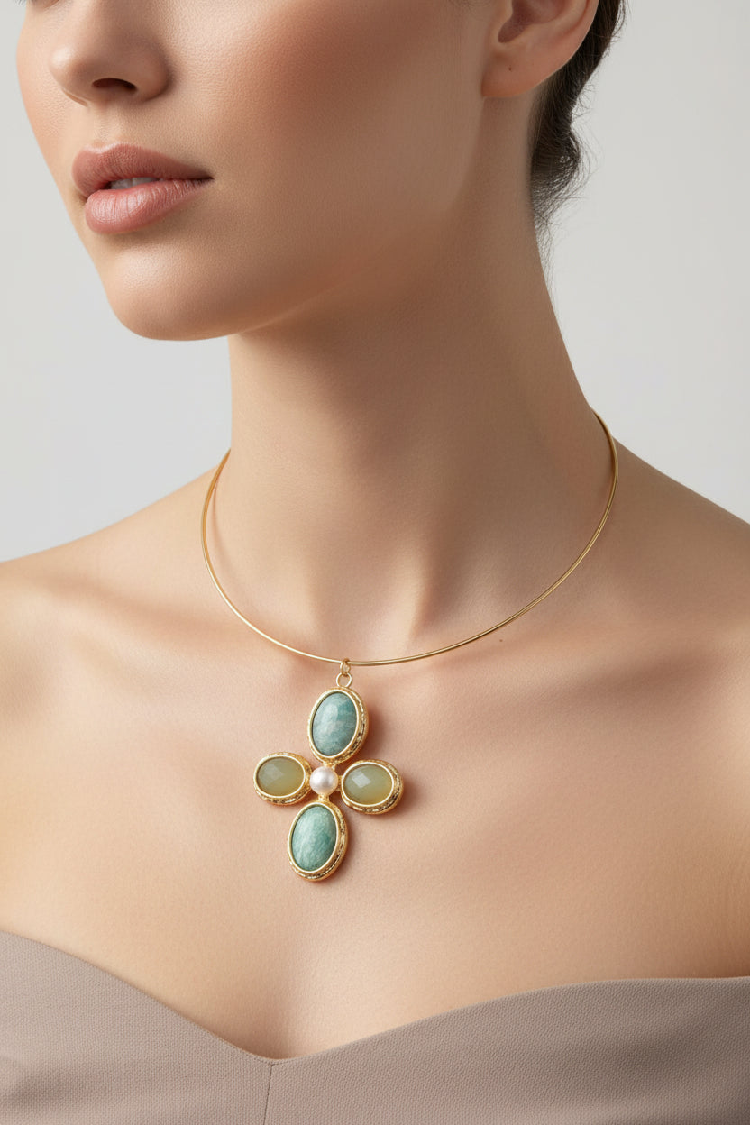 Gold necklace with green gemstones on a mannequin neck against a wooden background