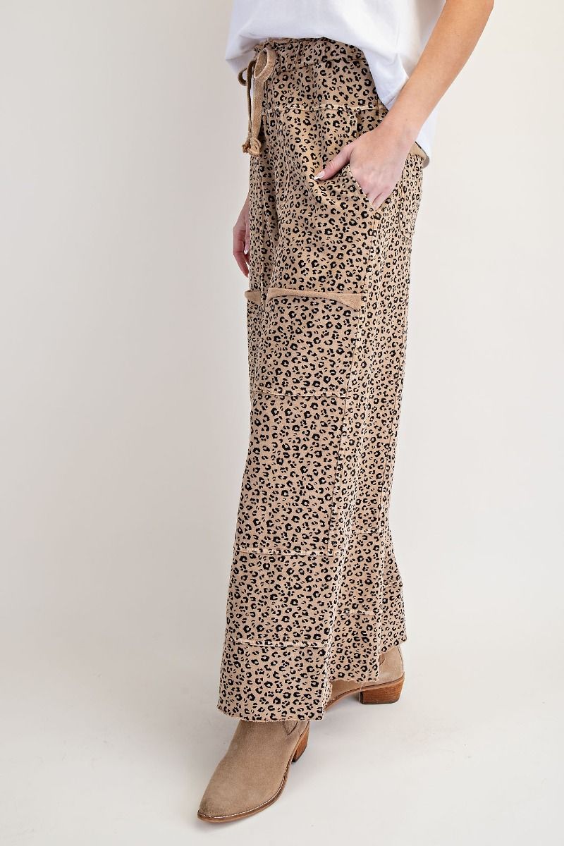 Leopard print pants worn by a person on a plain background