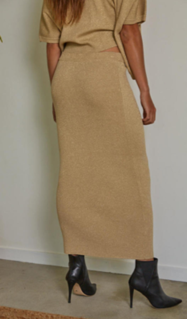 Person wearing a beige dress with a white wall background