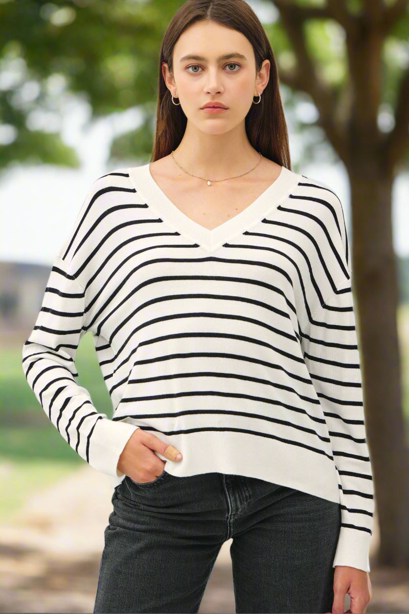 Woman wearing a black and white striped sweater against a plain background