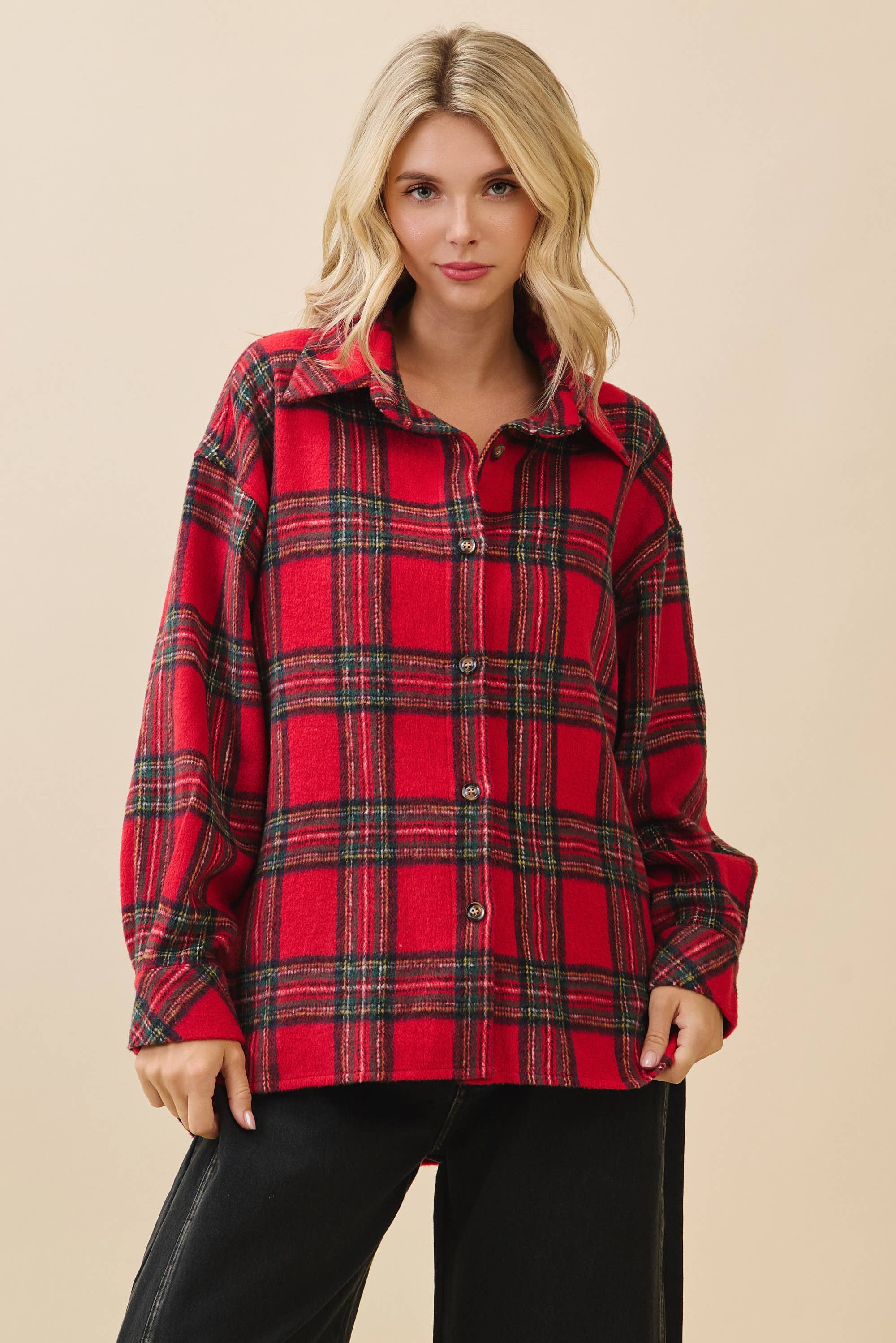 Woman wearing a red plaid shirt against a beige background