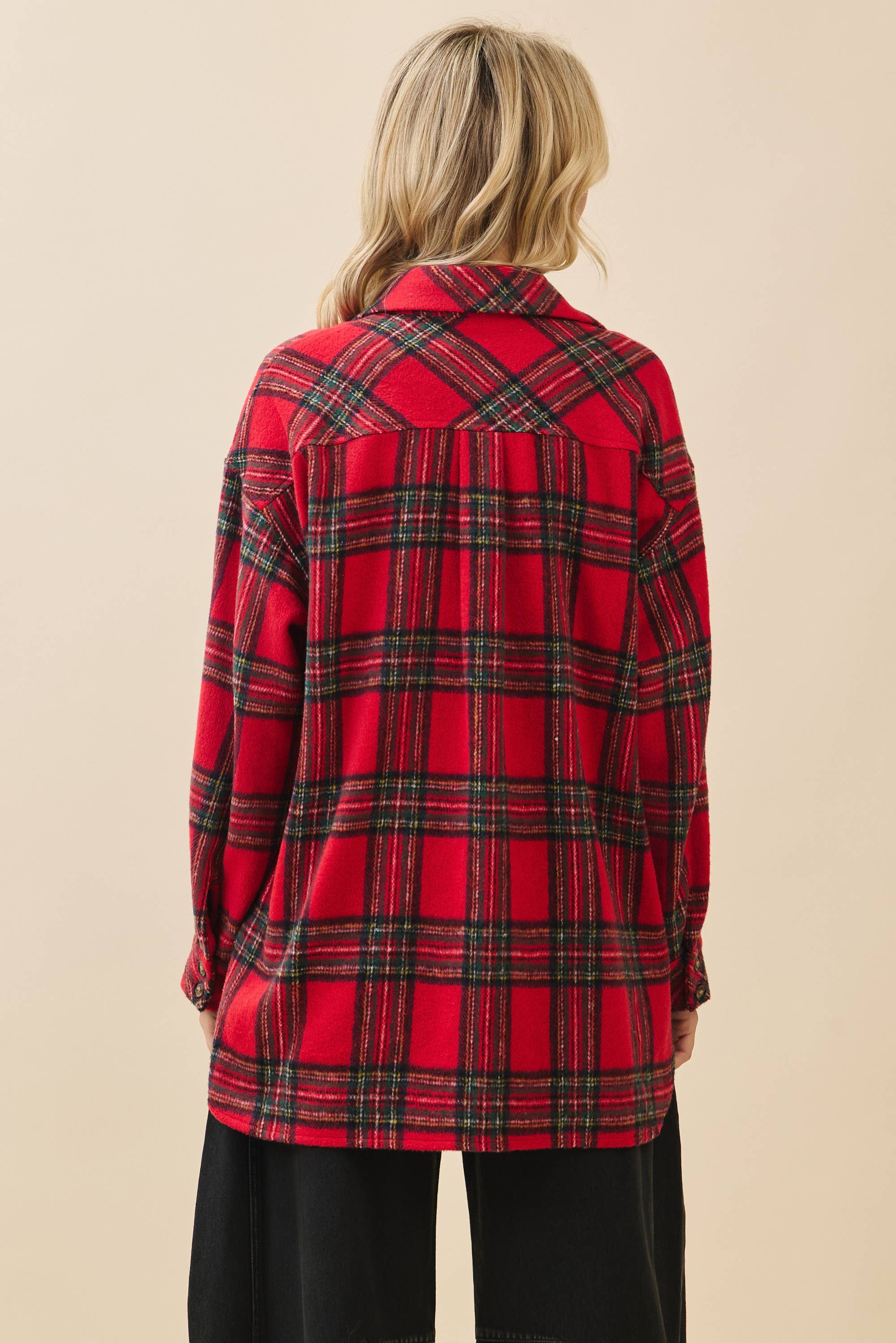 Red plaid shirt worn by a person on a beige background