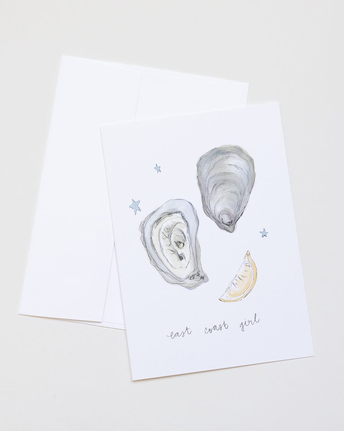Greeting card with oyster illustrations and 'east west girl' text on a white background