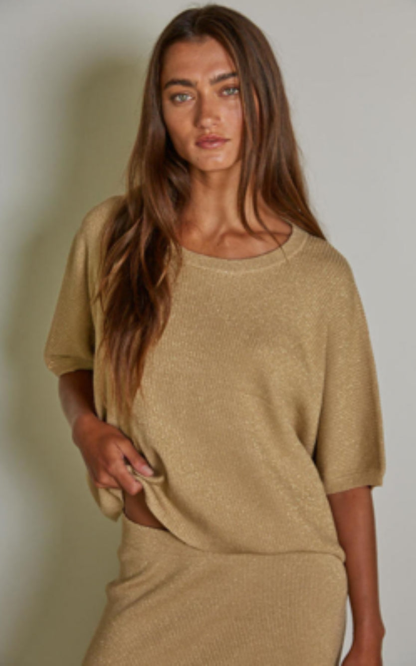 Woman wearing a beige outfit against a plain background