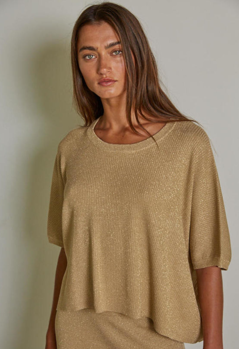 Woman wearing a beige sweater against a plain background