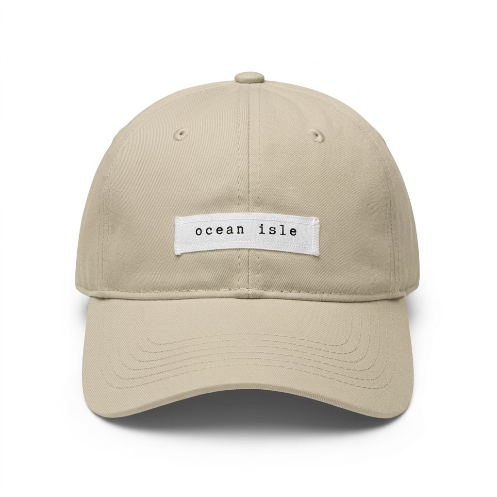 Beige cap with 'ocean isle' patch on a light surface
