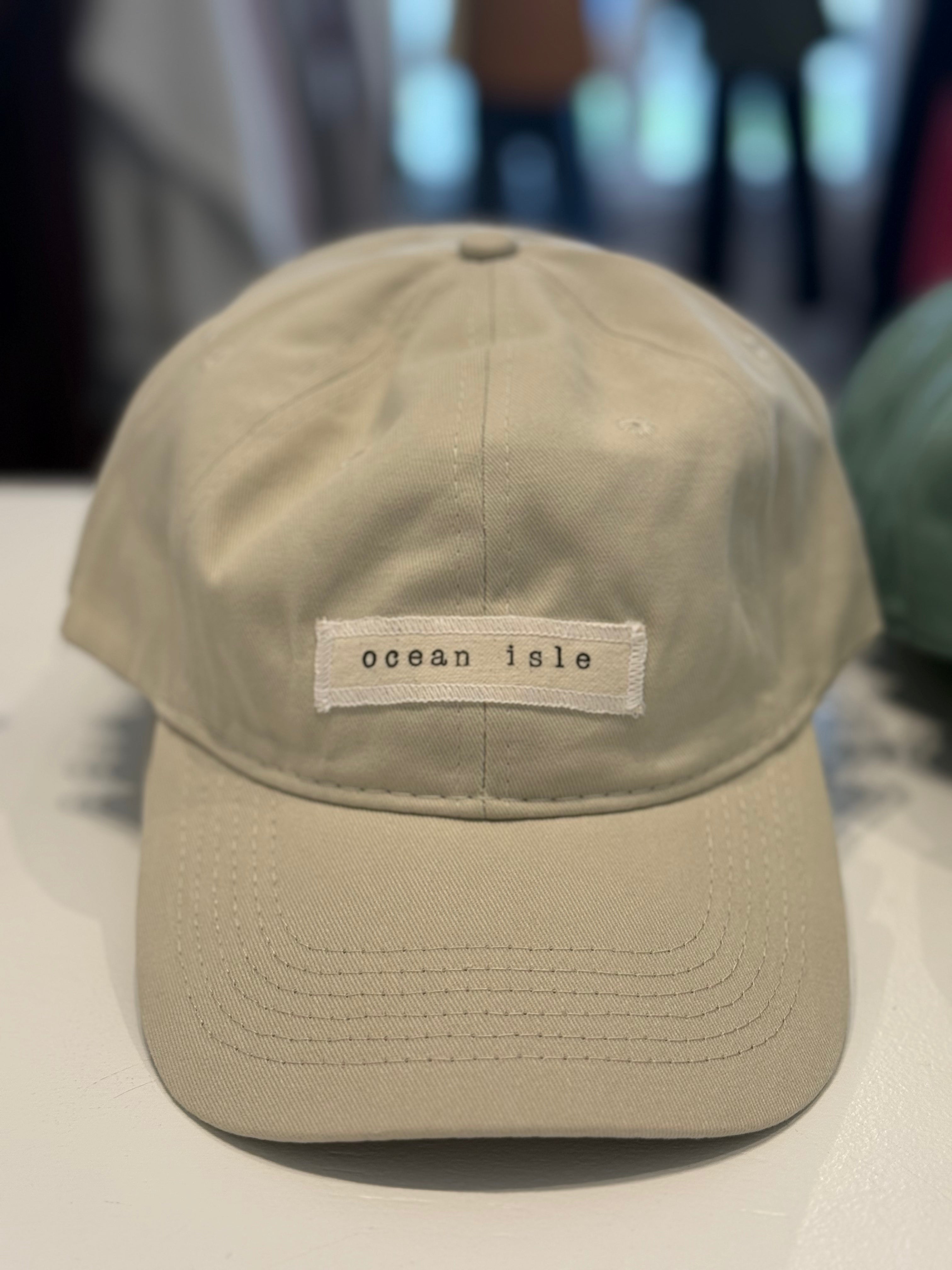 Beige cap with 'ocean isle' patch on a light surface