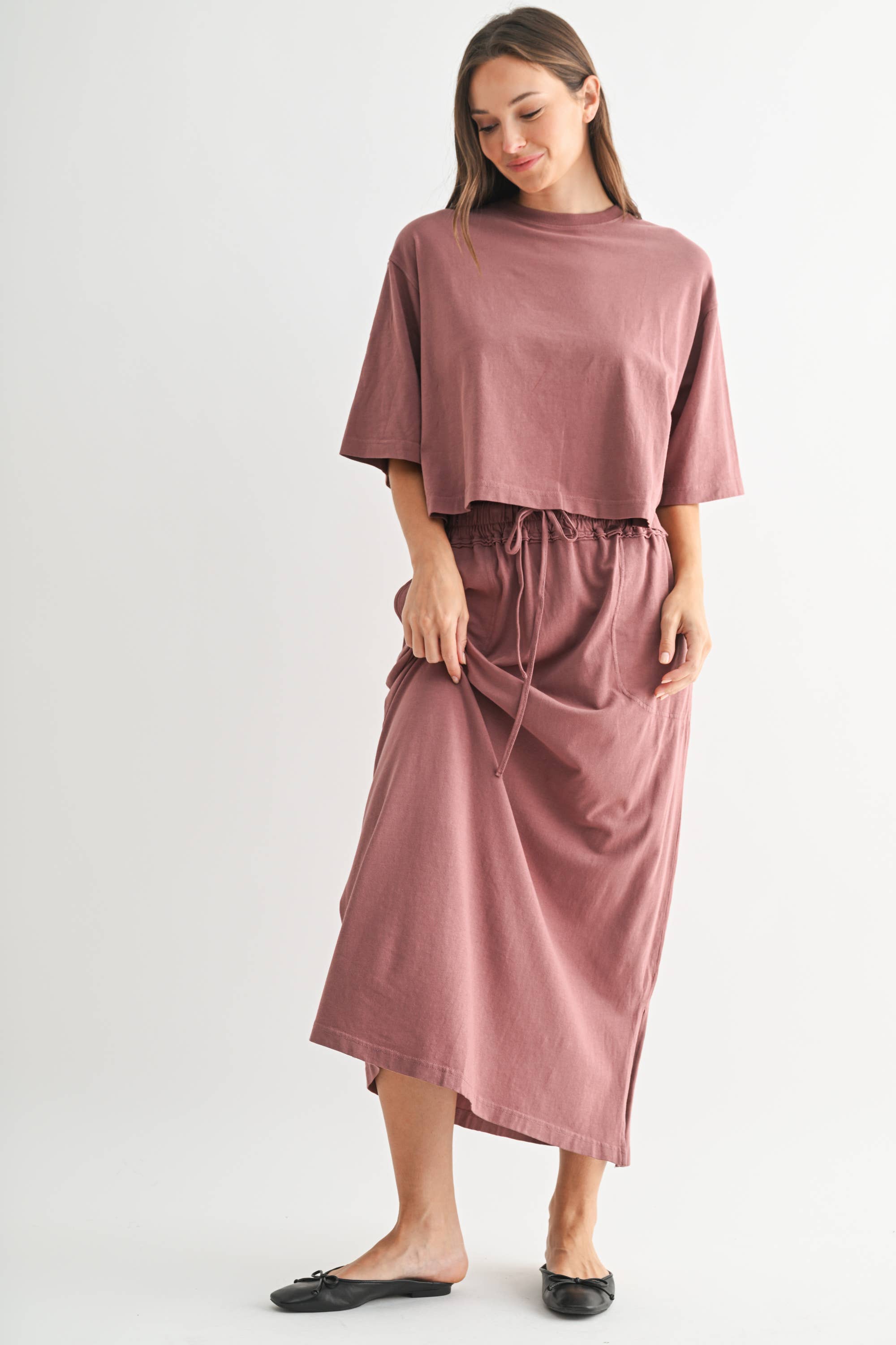 Woman wearing a mauve outfit on a white background