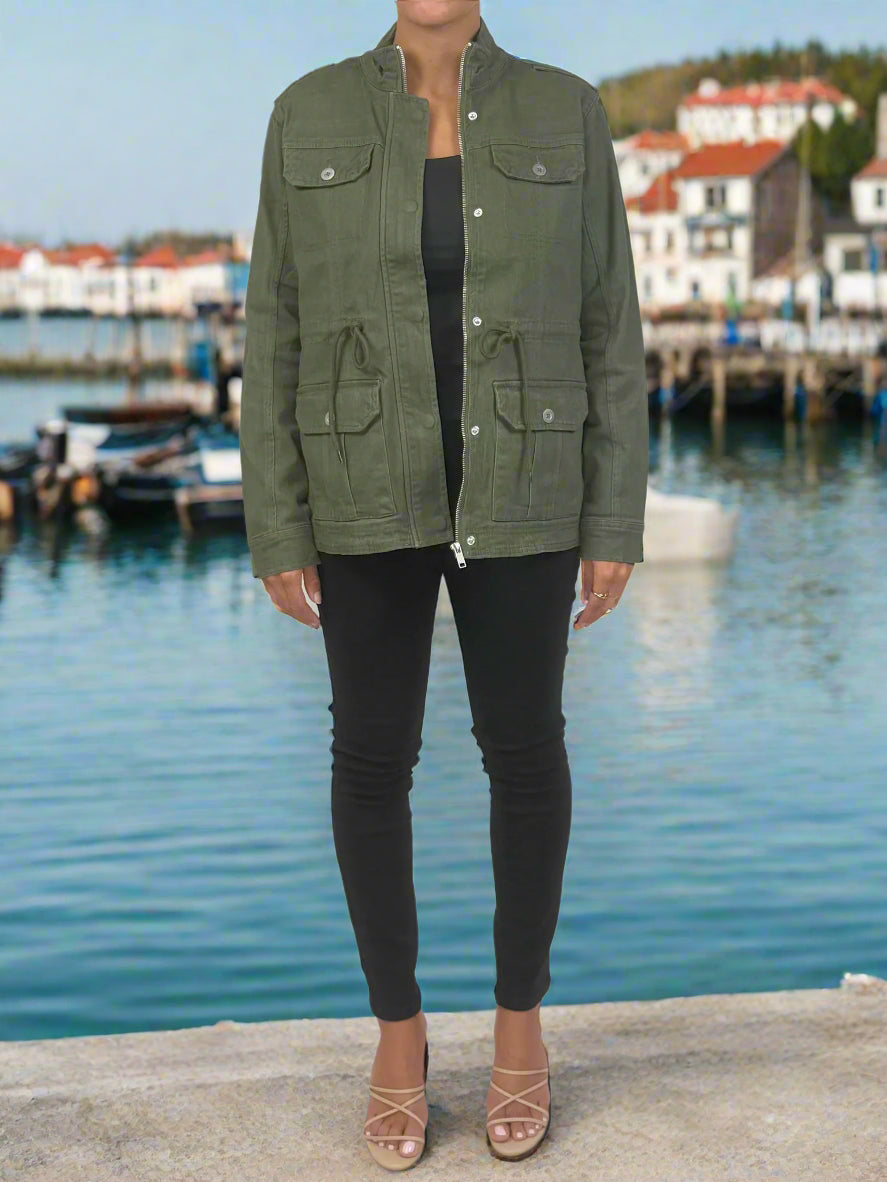Person wearing a green jacket and black pants on a white background