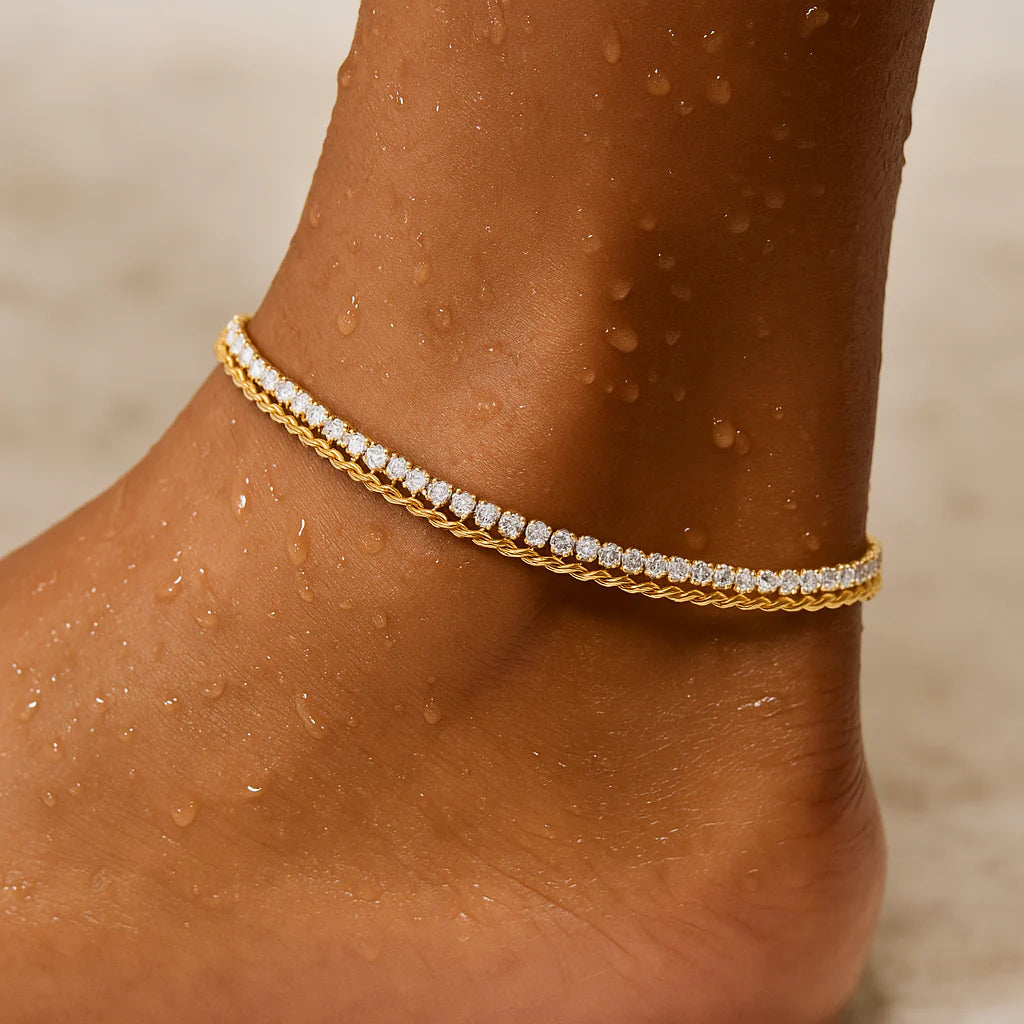 Gold anklet with small diamonds on a person's ankle against a neutral background