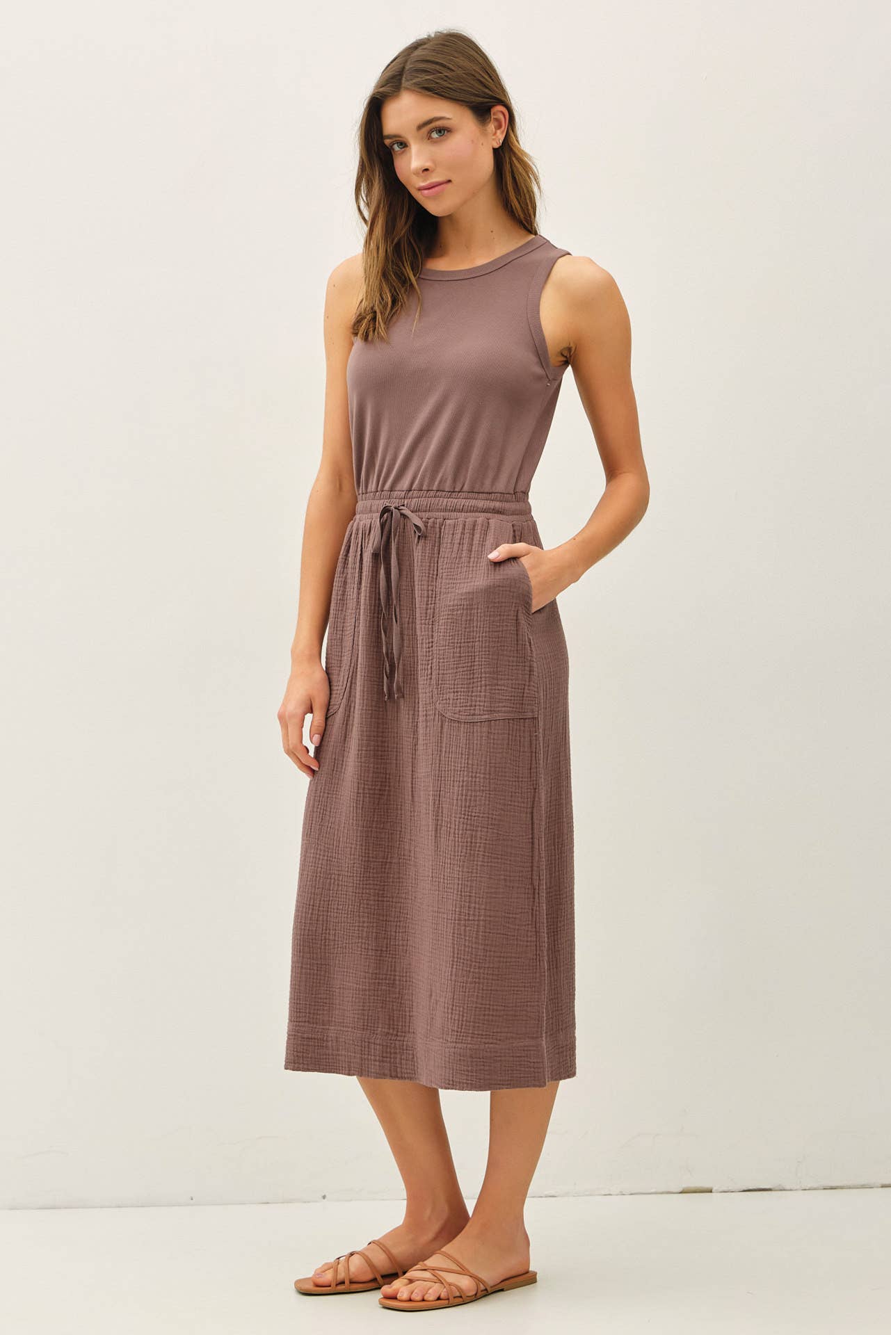 Woman wearing a brown sleeveless dress on a white background