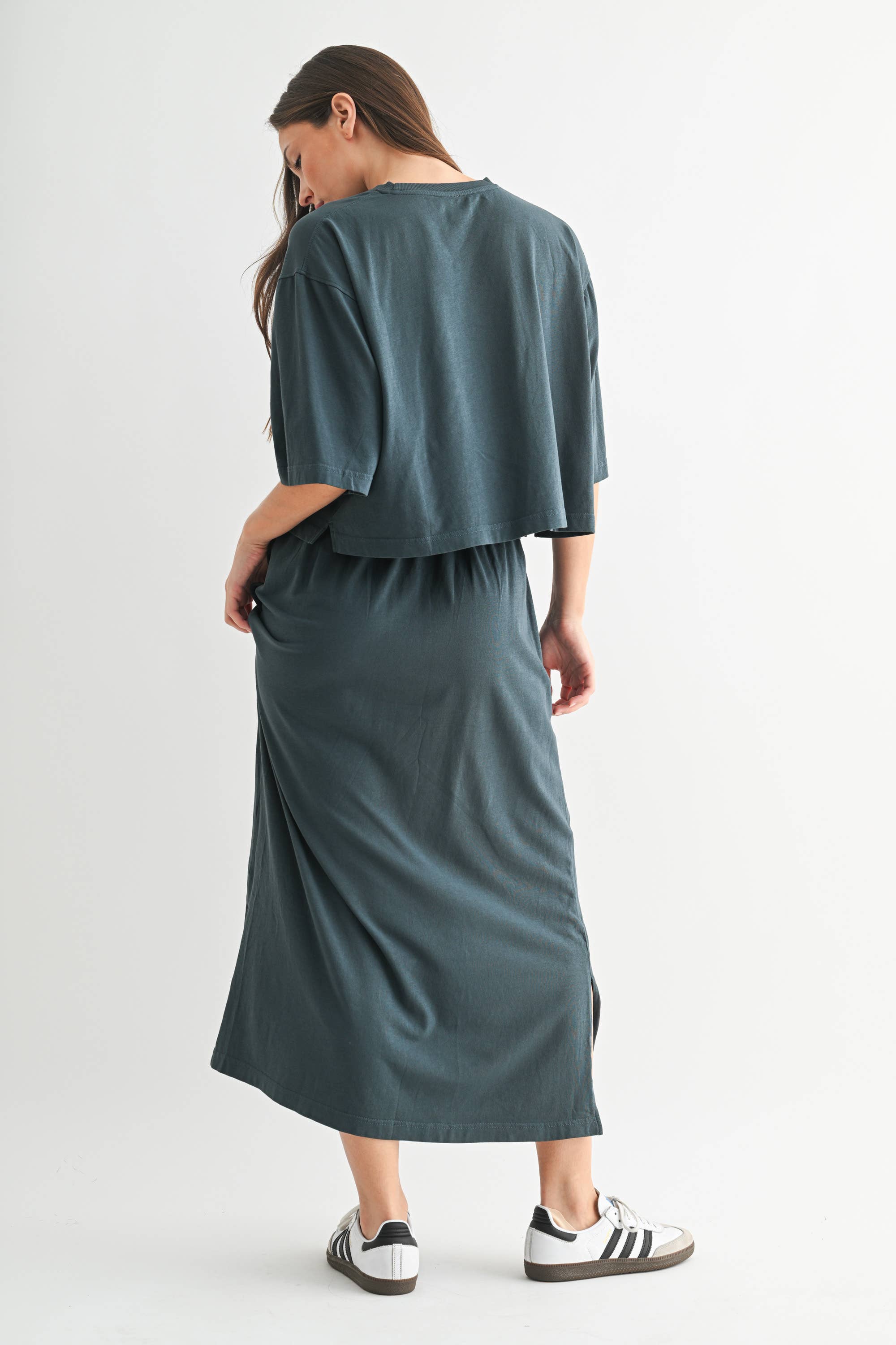 Woman wearing a teal dress with a plain background