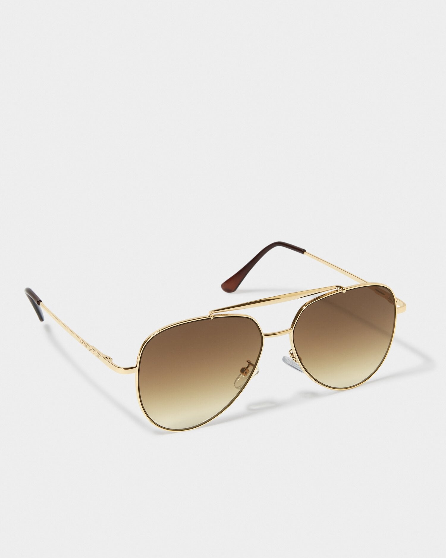 Aviator sunglasses with gold frame and brown lenses on a white background