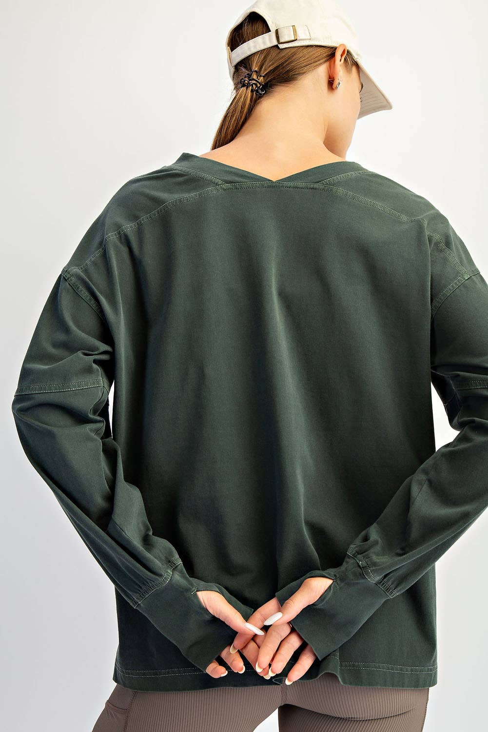 Person wearing a green long-sleeve shirt on a white background