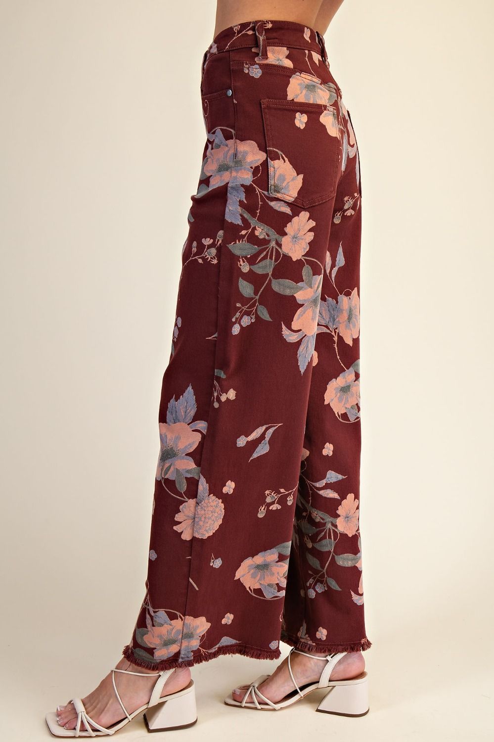 Floral-patterned pants worn by a person on a beige background