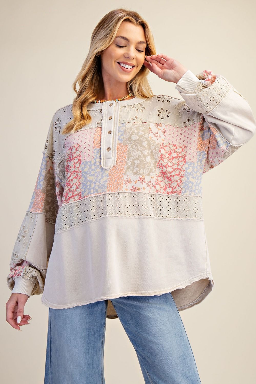 Woman wearing a floral patterned blouse with lace details on a beige background