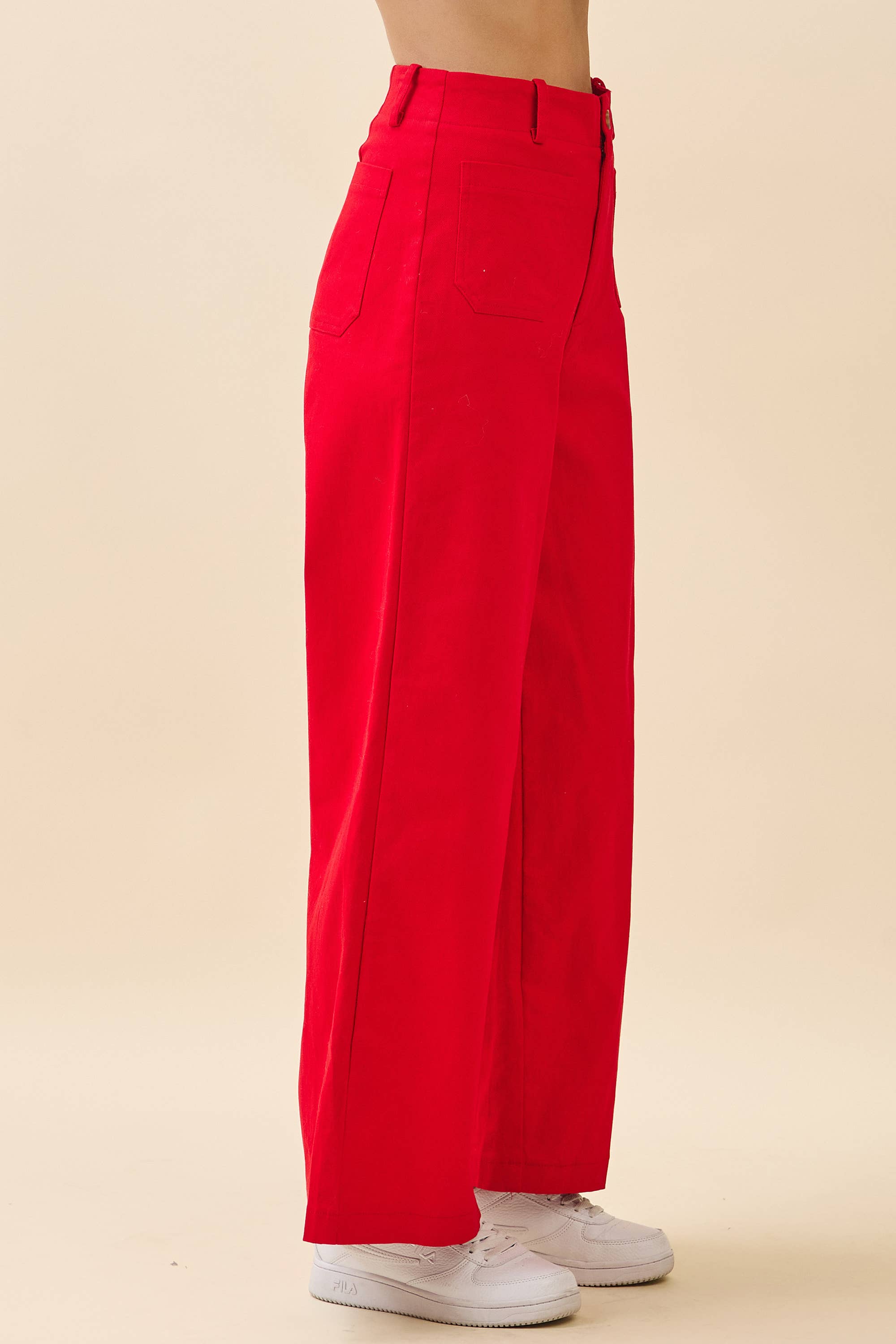 Red pants worn by a person on a beige background