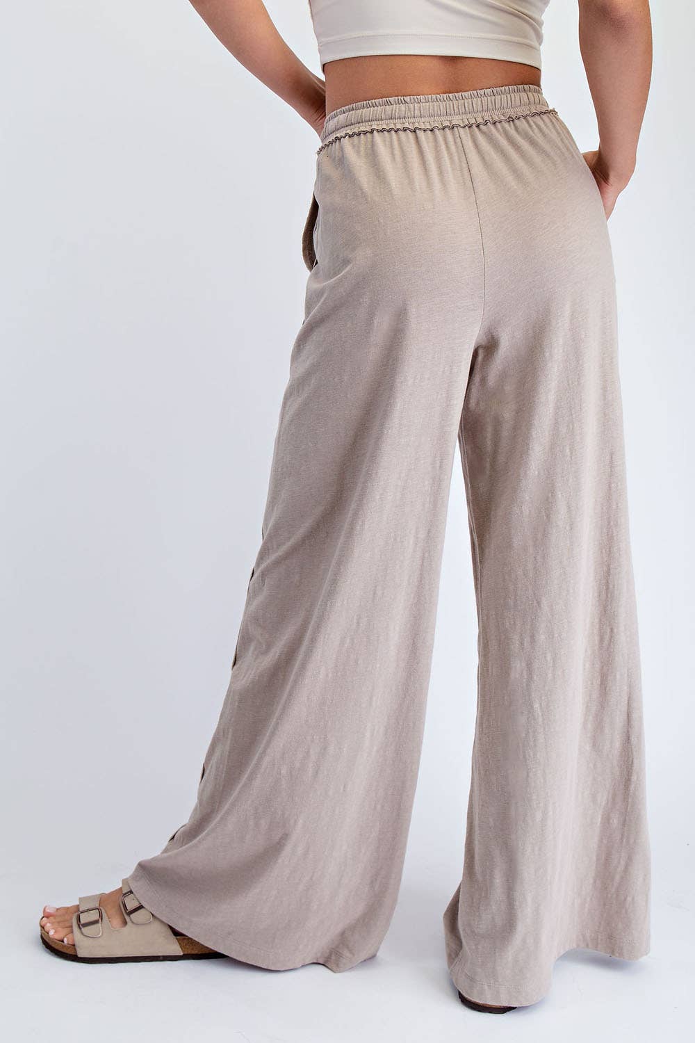 Beige wide-leg pants worn by a person on a white background