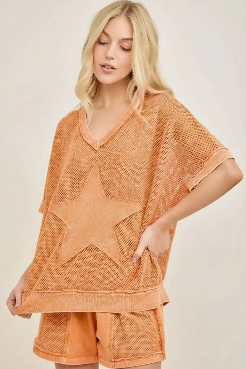 Woman wearing a pink star-patterned outfit on a plain background